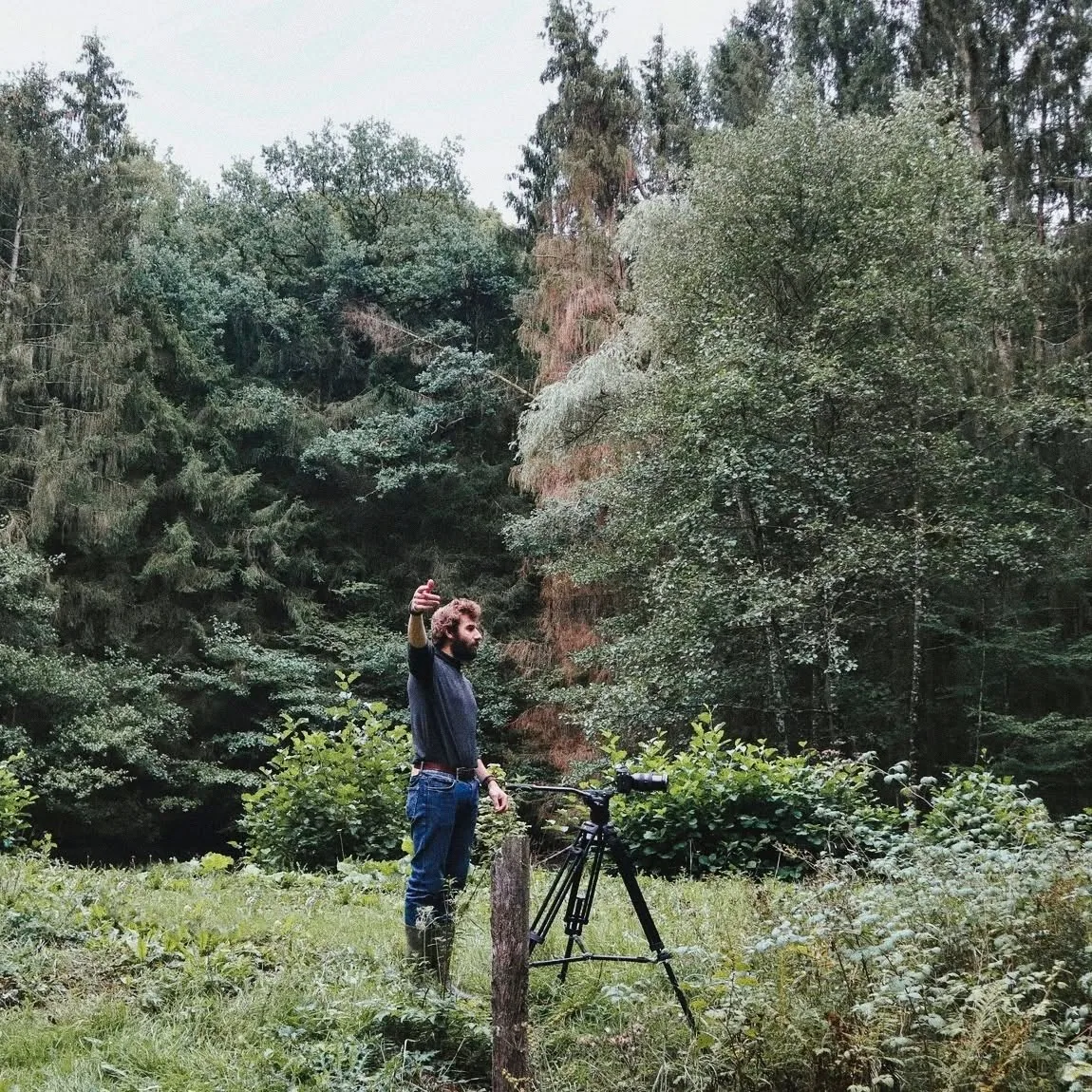 Louis en tournage avec une caméra sur trépied, au bord du bois